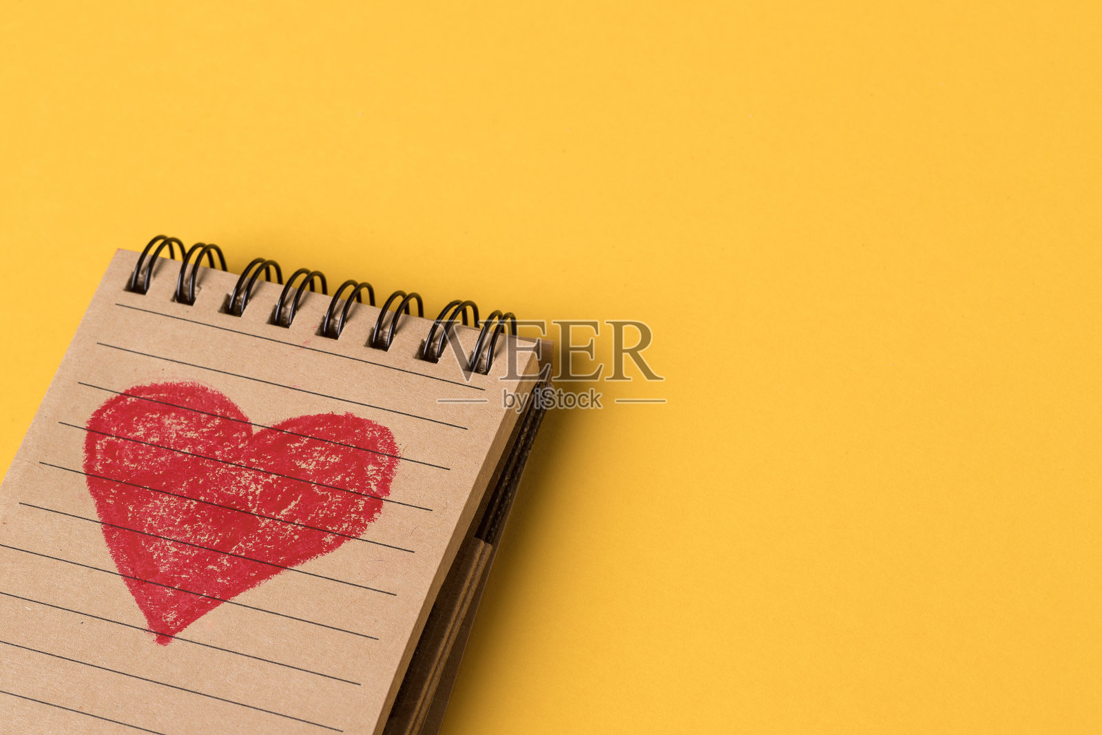 特写的红心画在笔记本上的黄色背景照片摄影图片