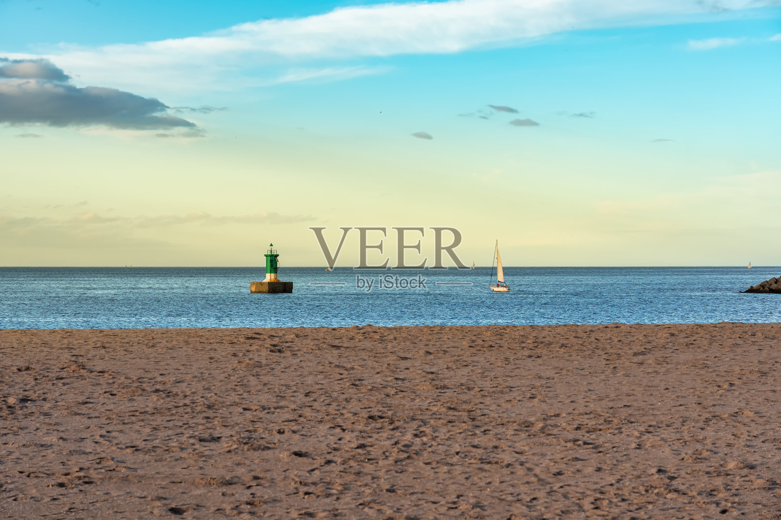 日落时分的沙滩上有小帆船航行，海上有浮标，希洪，阿斯图里亚斯。照片摄影图片