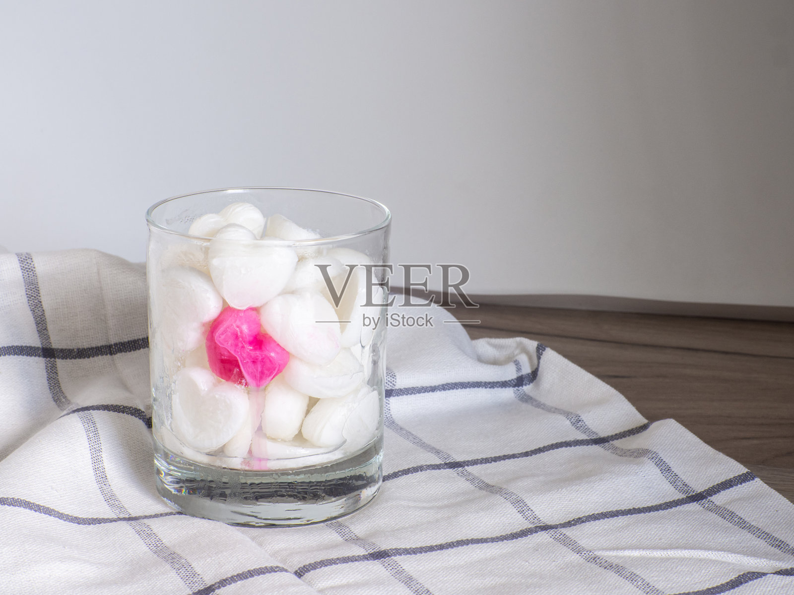 用牛奶制成的小冰块，放在玻璃杯里做成心形照片摄影图片