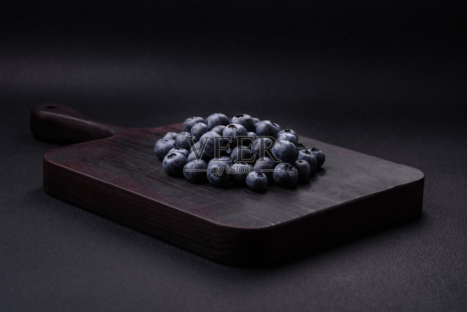 美味的新鲜蓝莓在质地的黑色混凝土背景上照片摄影图片