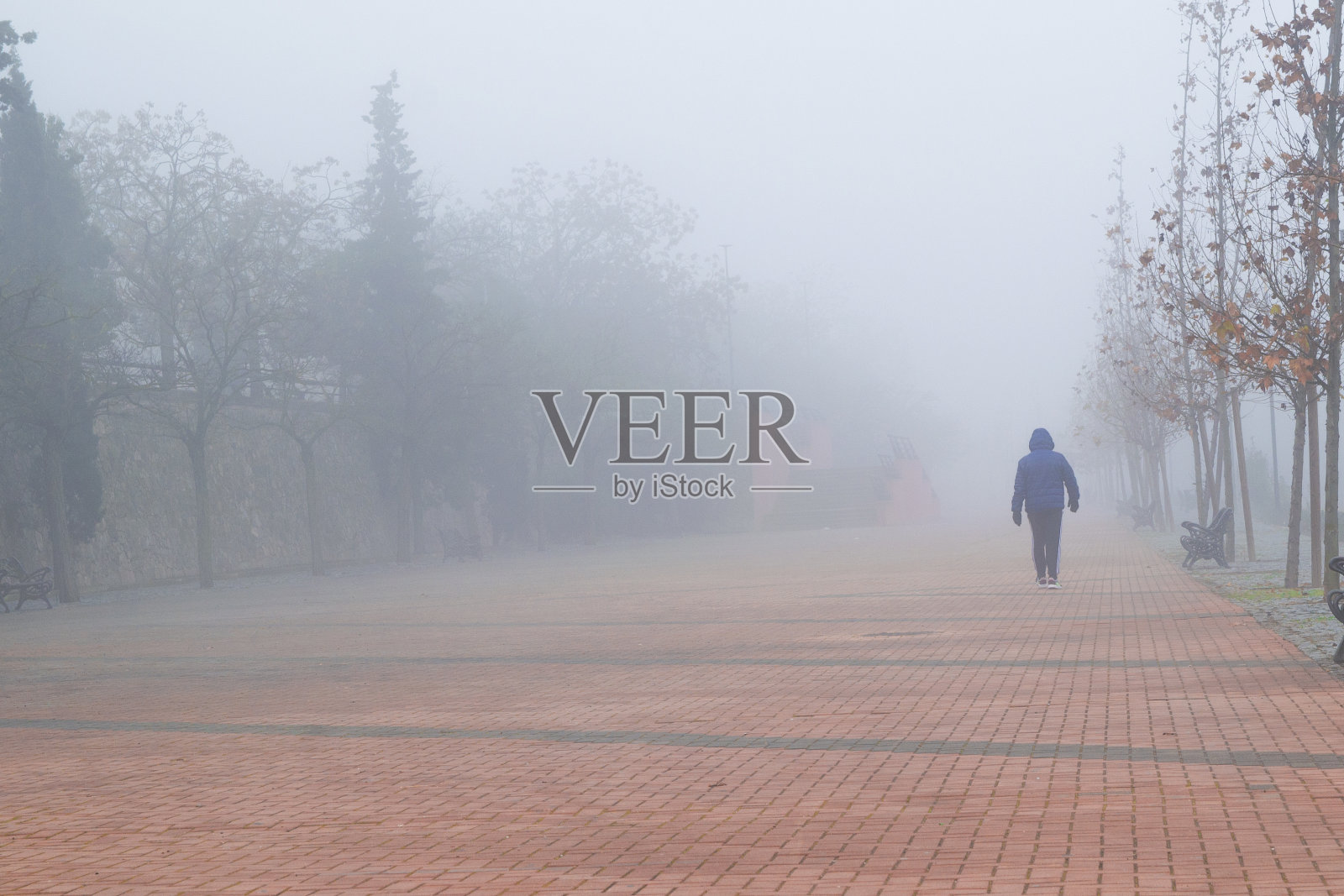 人们走在被雾覆盖的红砖人行道上照片摄影图片