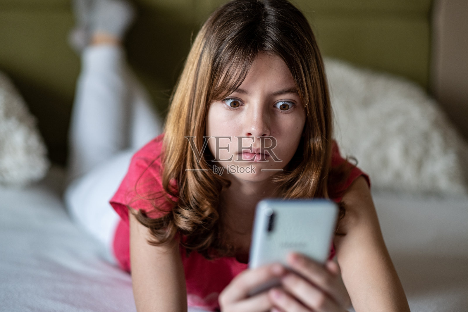 十几岁的女孩在看电话照片摄影图片