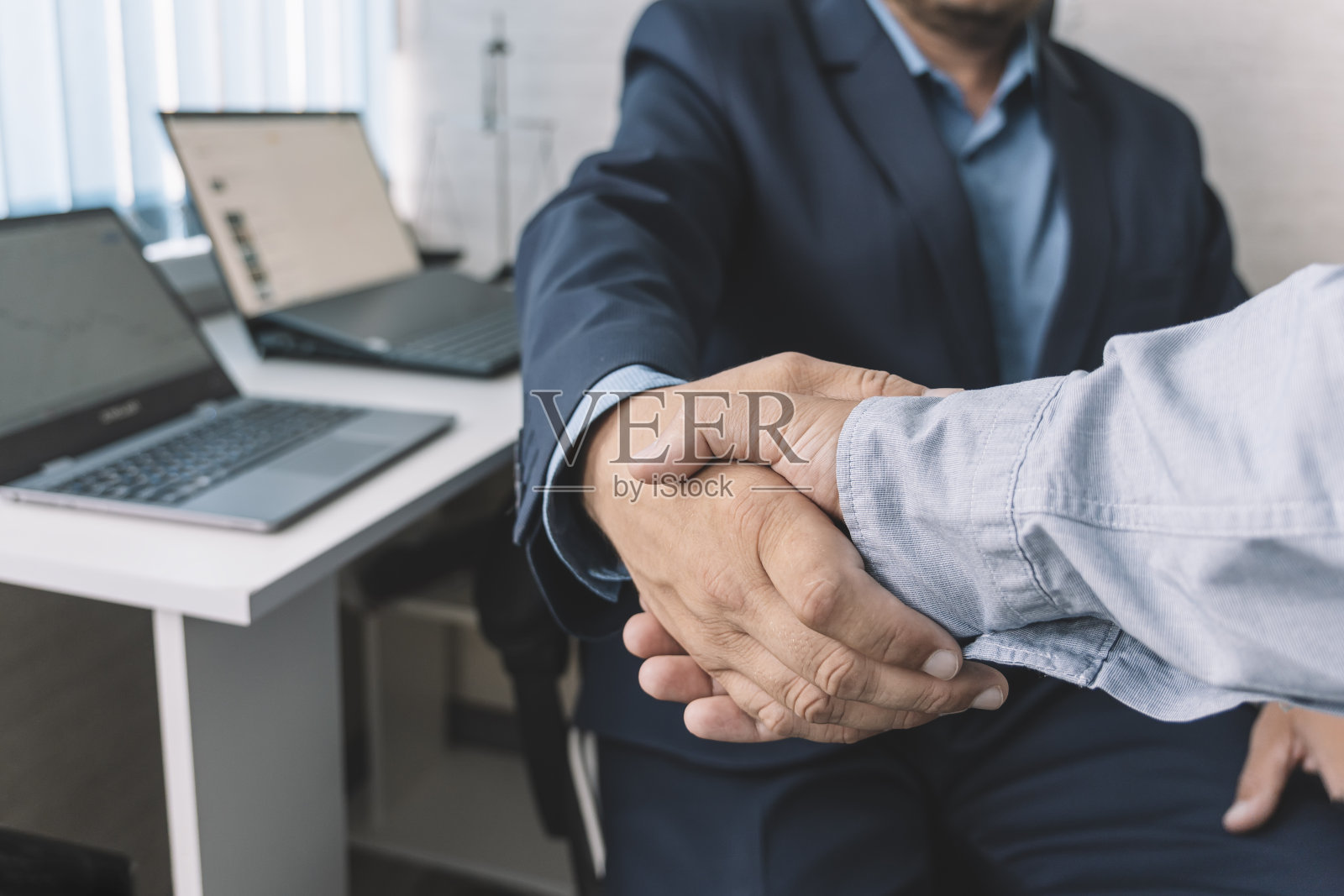 特写握手。商业中完美交易的概念。年轻经理与新员工握手。照片摄影图片