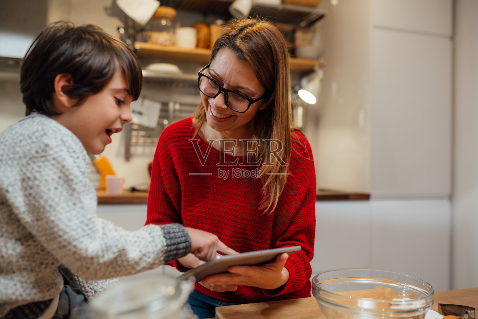 母亲和儿子一起在厨房烘焙照片摄影图片