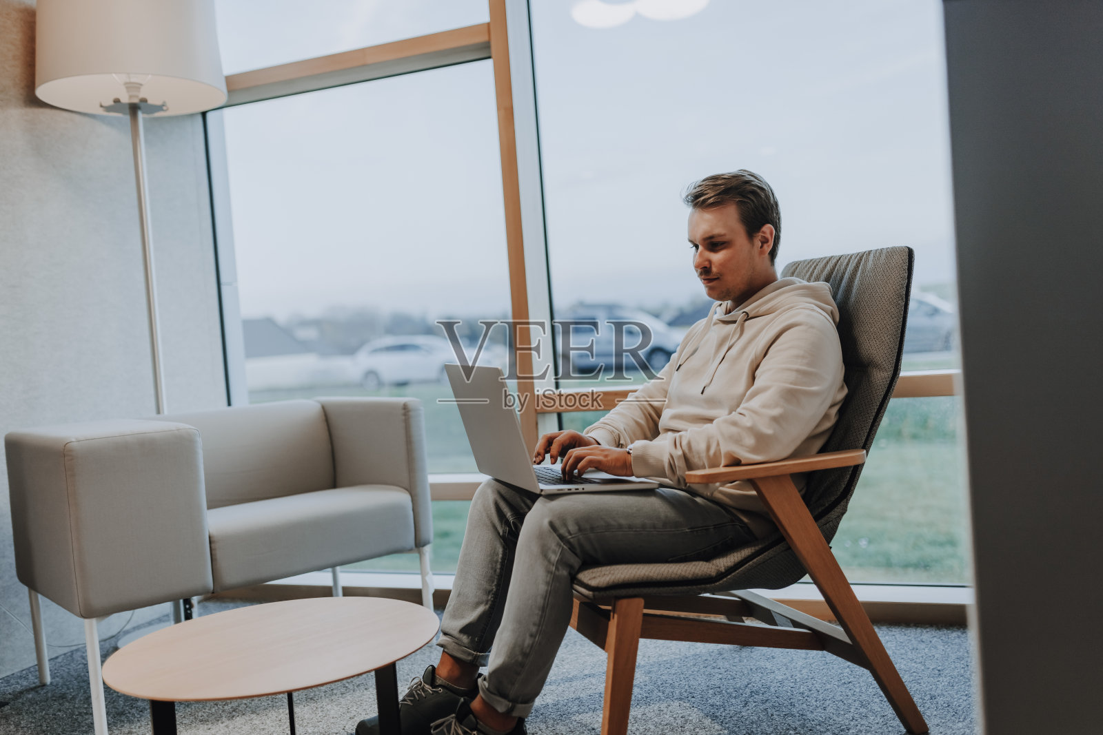 年轻的商人正在笔记本上写字，由于新冠肺炎大流行，他在家里的办公室里忙着努力工作照片摄影图片