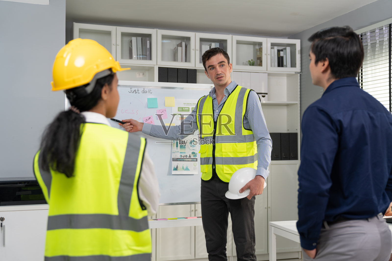 在工地办公室的会议室里，工程师领导在白板上与商业公司介绍成功的项目和战略计划照片摄影图片