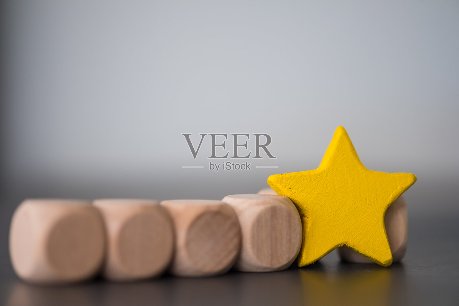 一颗站立的木头黄色星星。一星评价。照片摄影图片