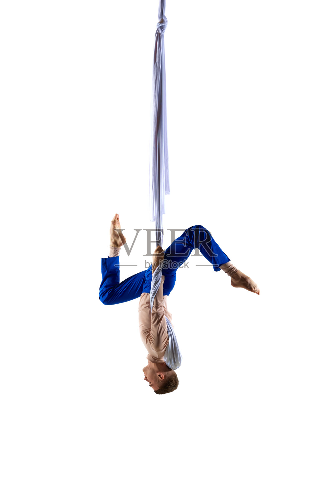 颠倒了。年轻男性专业空中体操运动员，杂技演员在空中织物上训练，背景是白色的工作室照片摄影图片