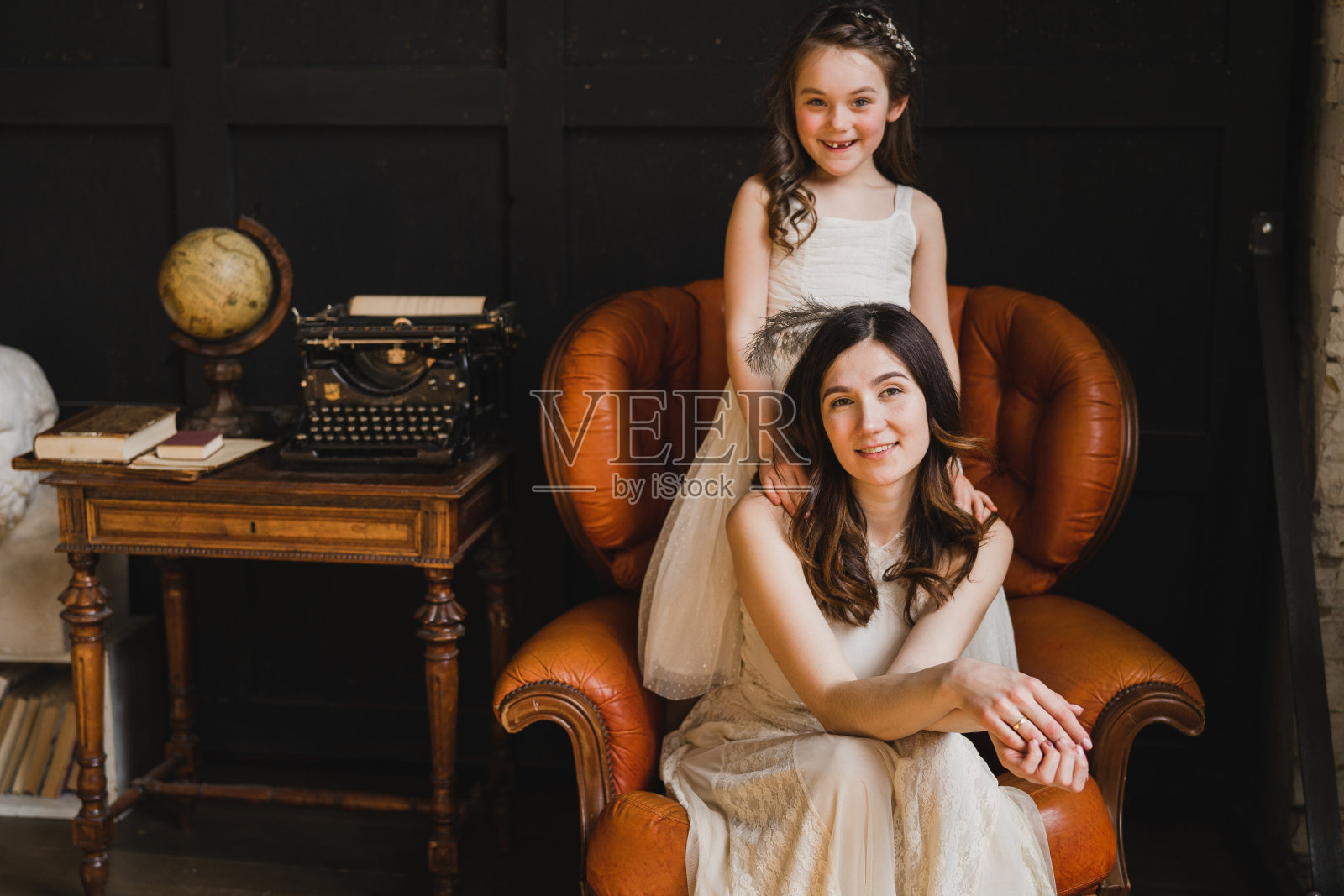 快乐的白人母亲和女儿拥抱，一起在室内玩耍。漂亮的小女孩和漂亮的女人。祝您母亲节快乐。照片摄影图片