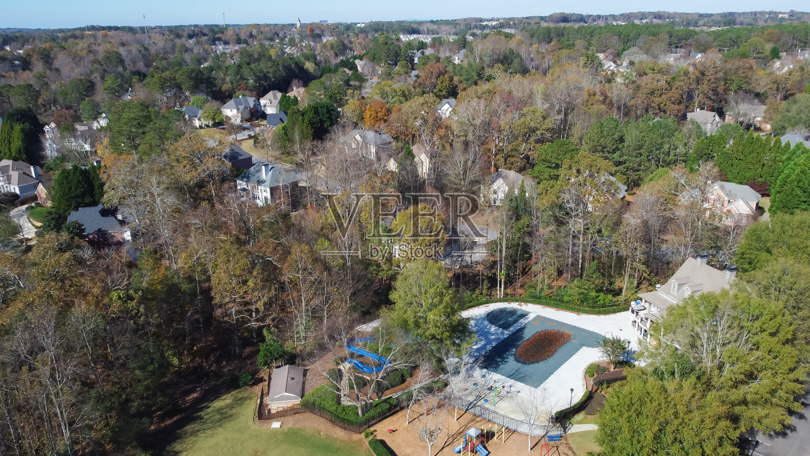 郊区住宅坐落在郁郁葱葱的绿草区，业主协会的游泳池，操场围绕着高大成熟的树木木材，美国佐治亚州亚特兰大郊区照片摄影图片