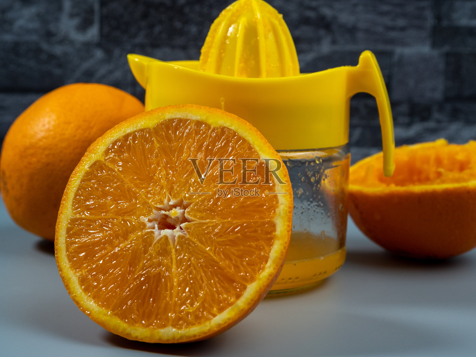 橙子榨汁机里有成熟的橙子。新鲜果汁。照片摄影图片