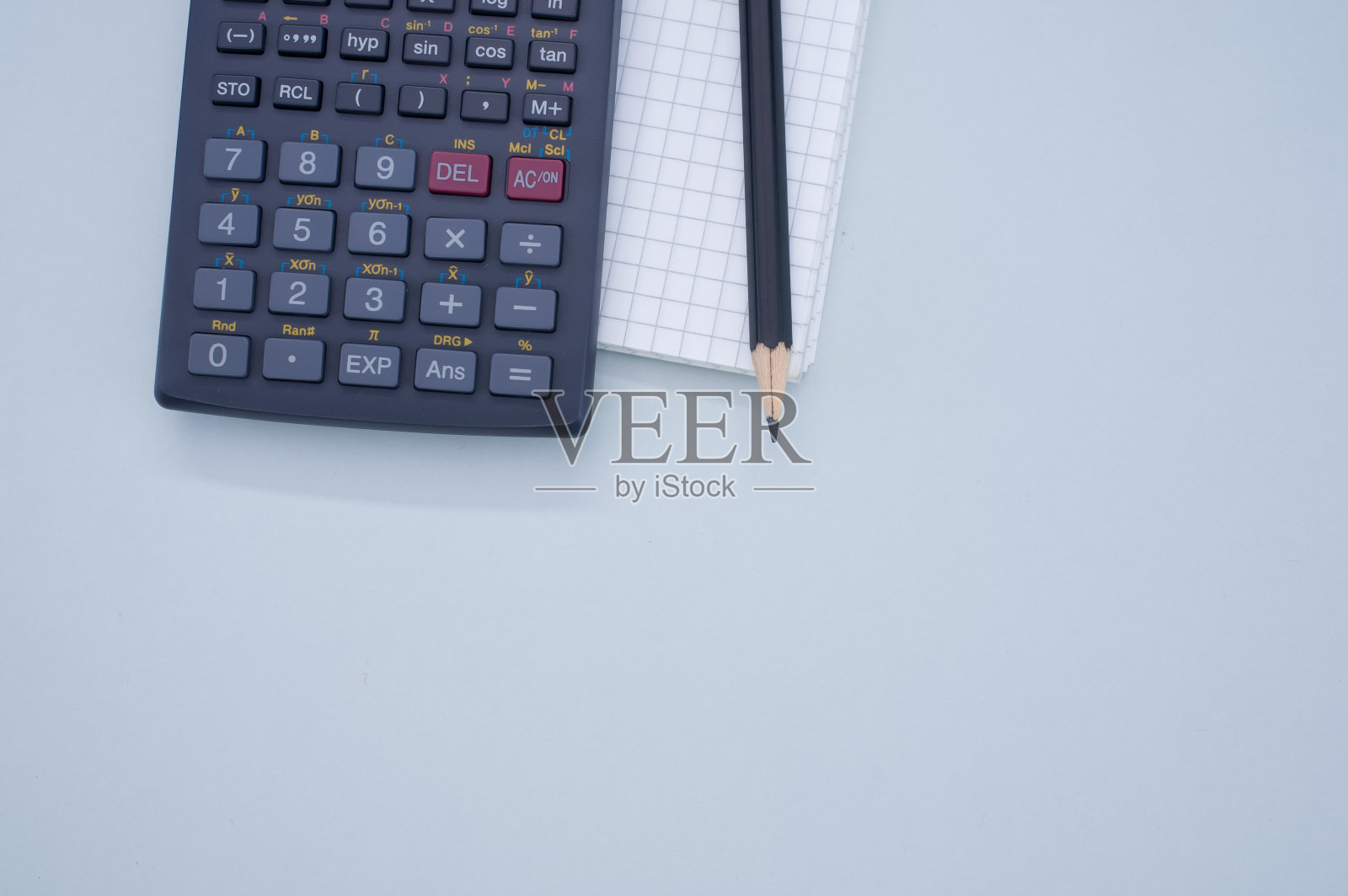 一个科学计算器，纸，铅笔孤立在灰色背景的俯视图照片摄影图片