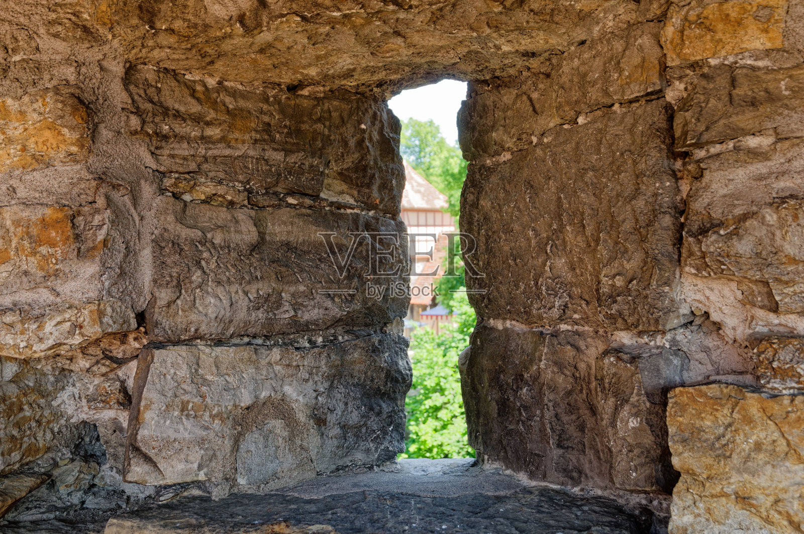 一个狭窄的窗口，一个古老的石头建筑，郁郁葱葱的绿色景观照片摄影图片
