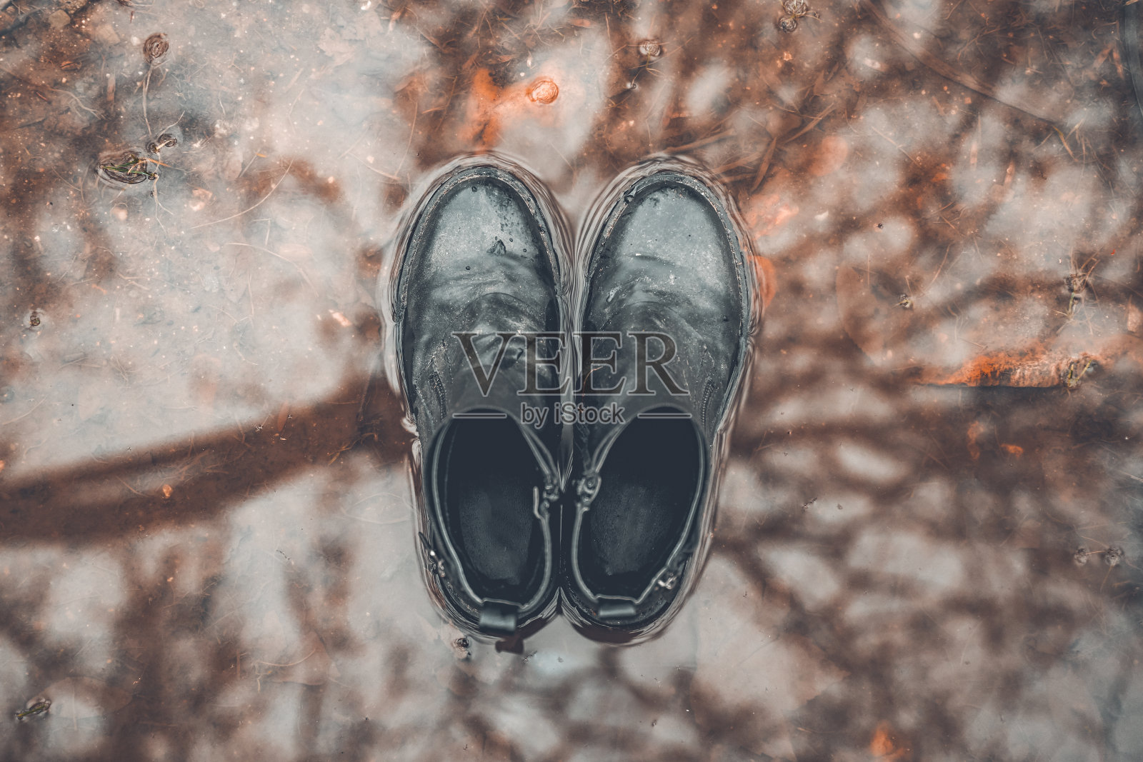 水坑上黑色靴子的俯视图照片摄影图片