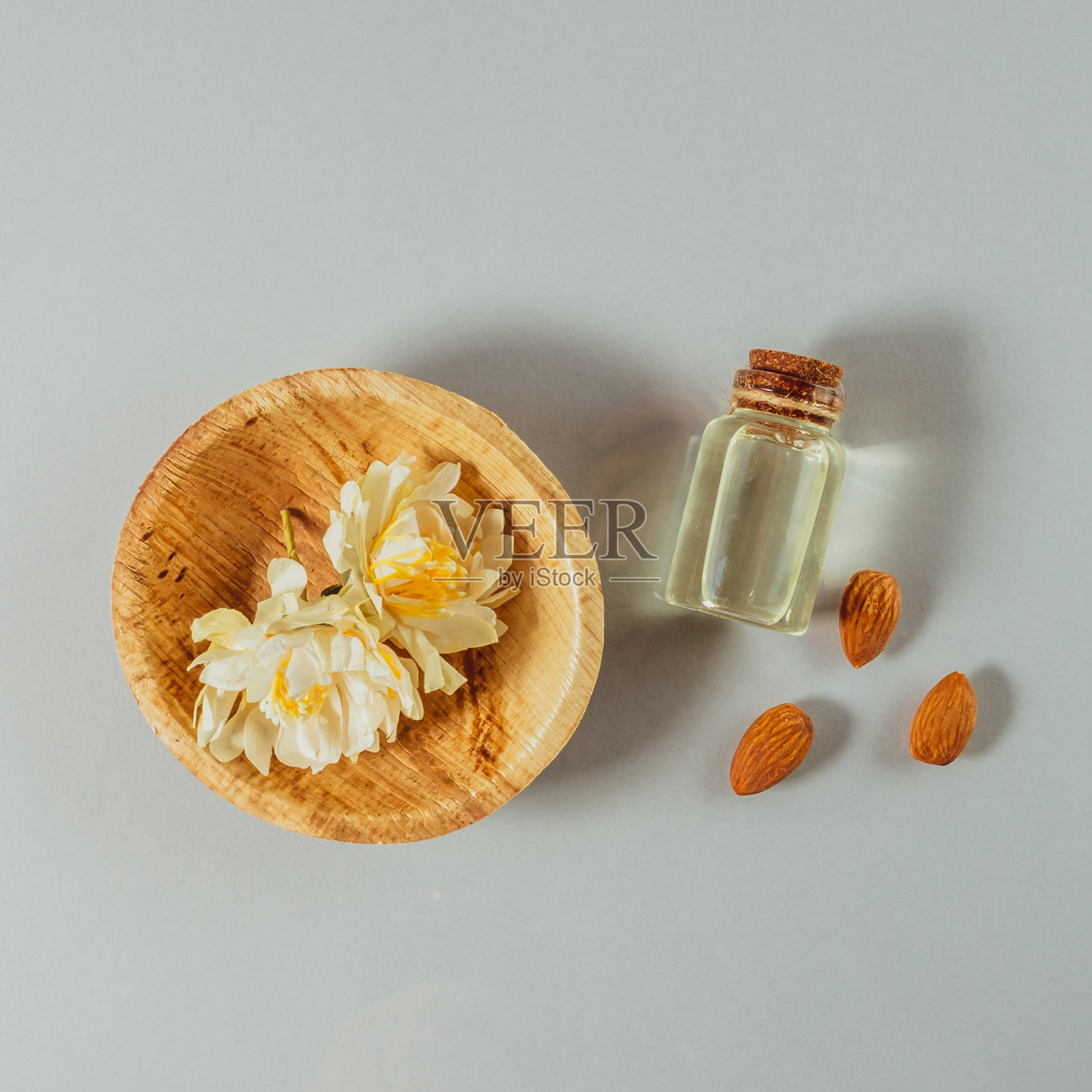 杏仁油天然护肤产品与小瓶和杏仁在灰色背景照片摄影图片