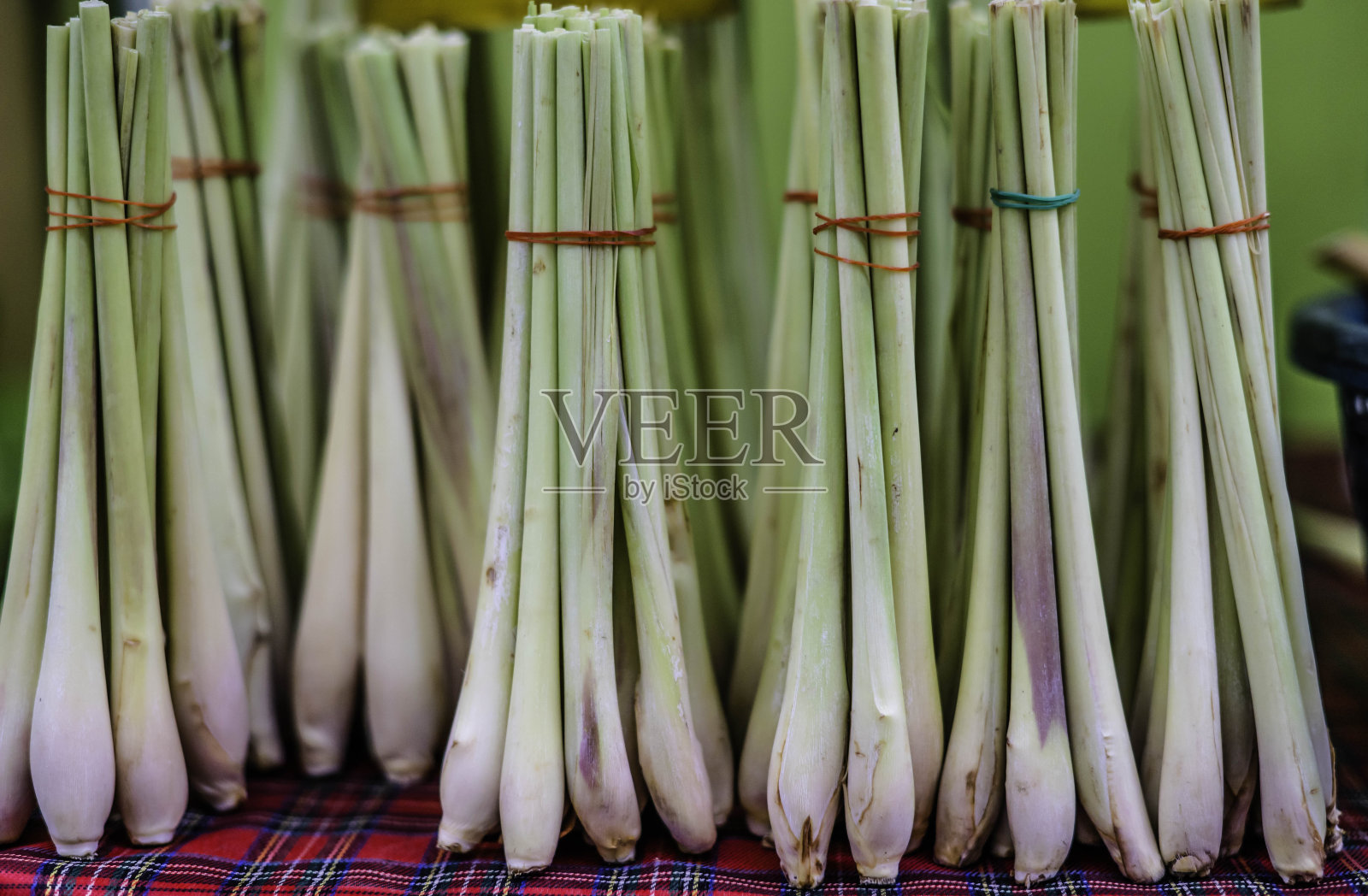 用橡皮筋捆成捆的柠檬草在泰国当地的一个食品市场出售。照片摄影图片