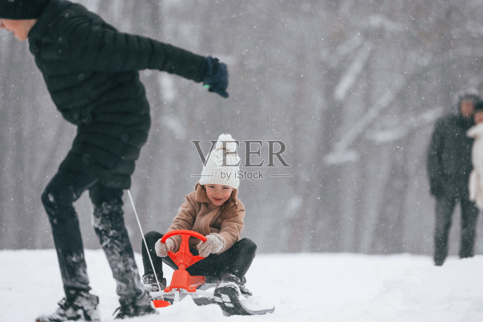 玩雪橇玩得很开心。幸福的家庭在户外，一起享受冬天的雪时光照片摄影图片