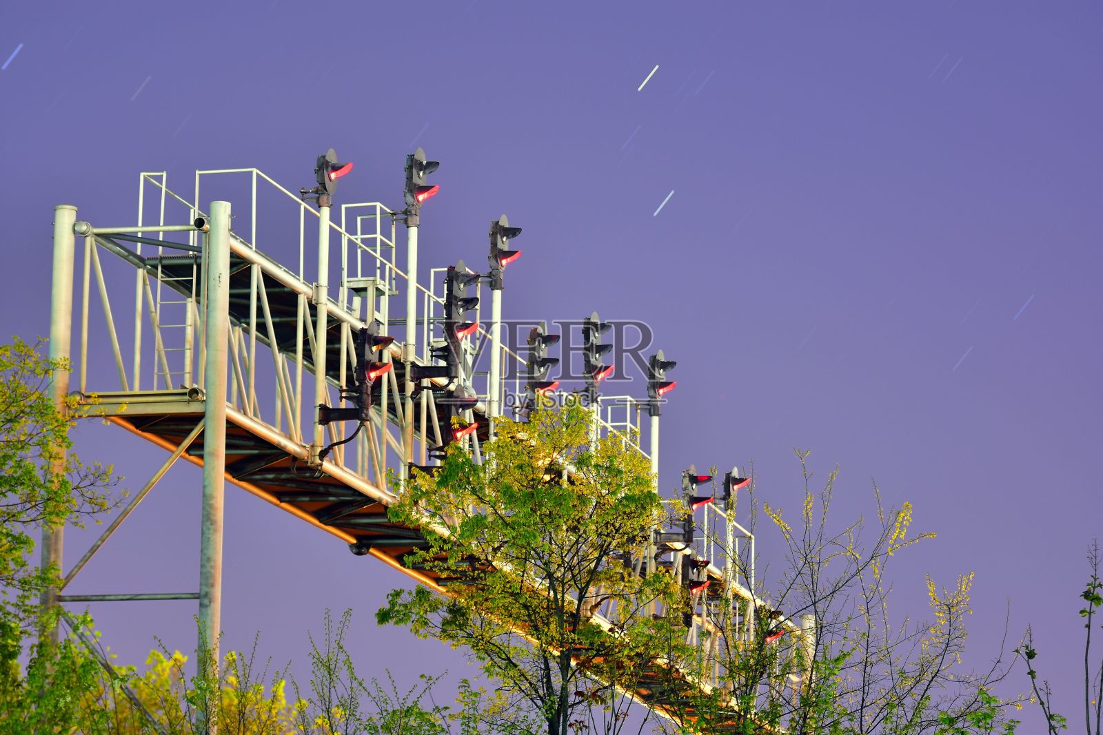 多个交通灯显示红色和绿色植被在天空的背景照片摄影图片