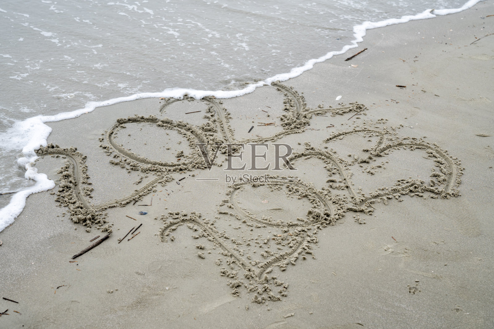 2023年写在沙子上，而2022年被海浪冲到海滩上照片摄影图片