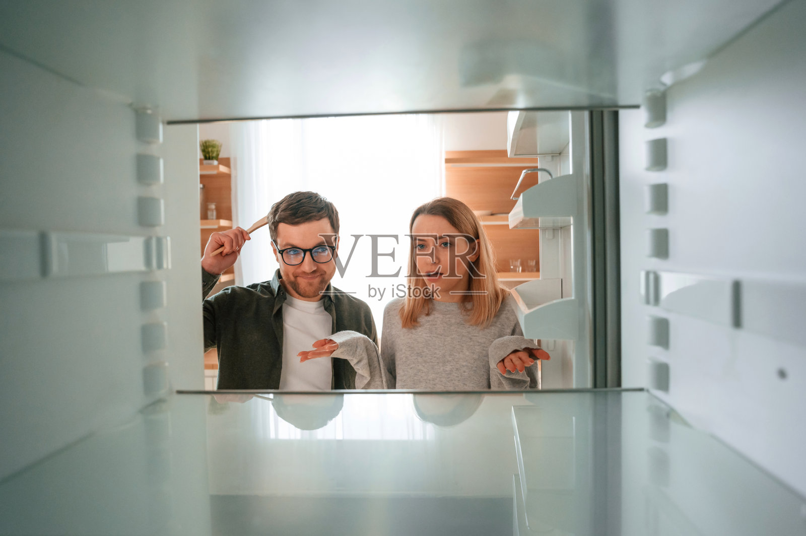 一个女人在厨房里向丈夫抱怨冰箱空了照片摄影图片