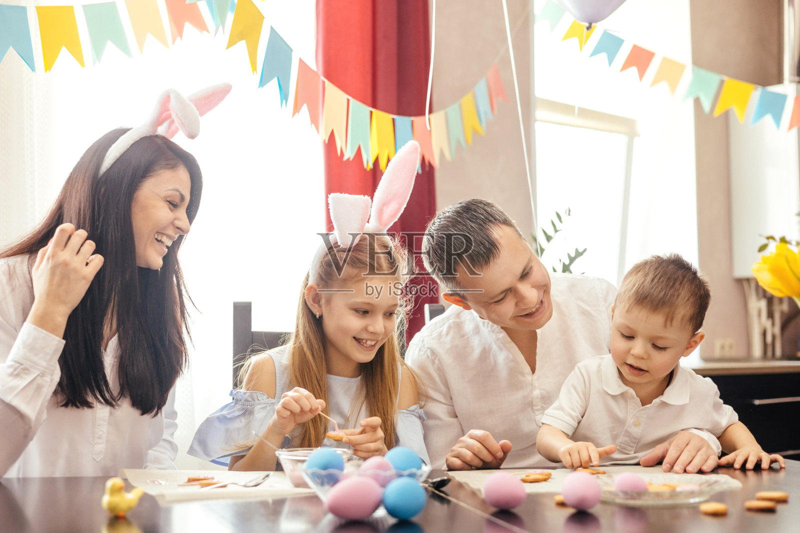 一个友好的家庭画复活节彩蛋和笑。照片摄影图片