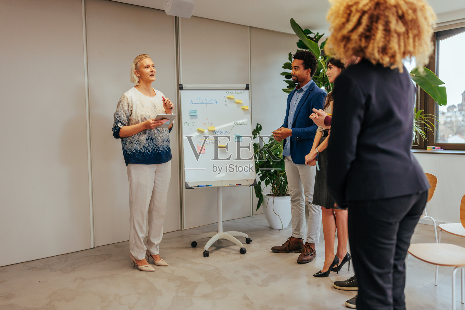 女企业主与同事在会议。照片摄影图片