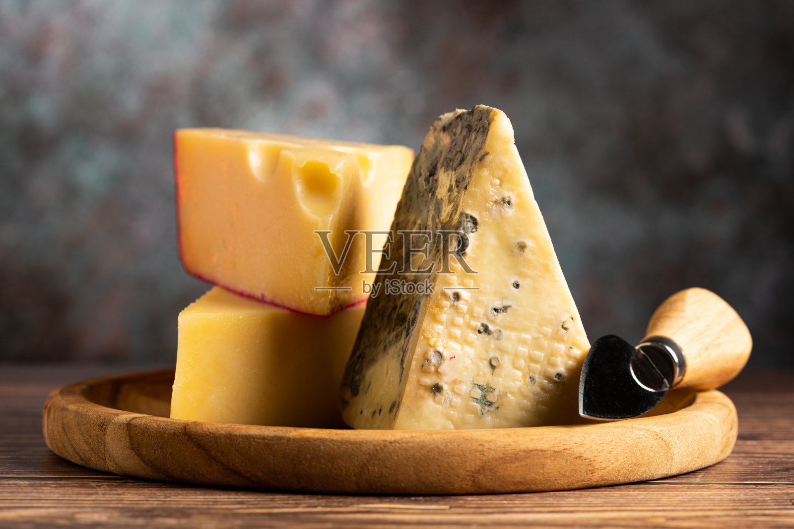 桌上放着一盘不同的奶酪。照片摄影图片