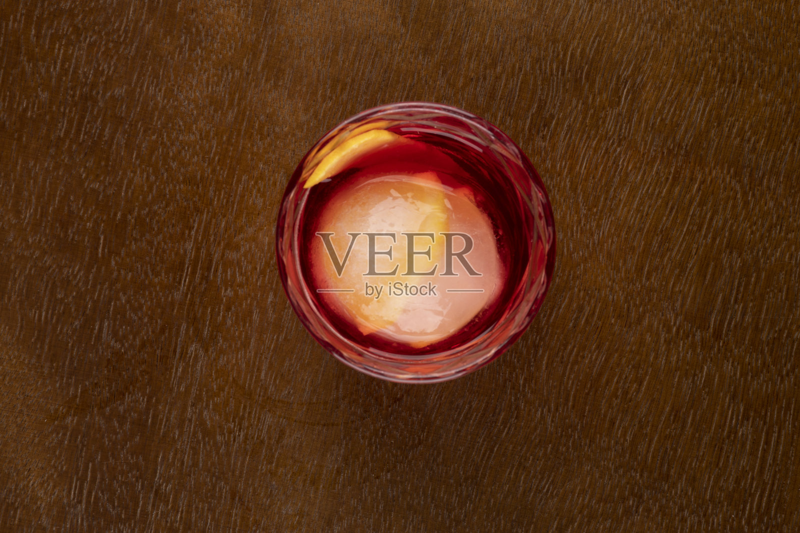 内格罗尼鸡尾酒顶部视图与圆形橙色冰在木桌顶部视图照片摄影图片