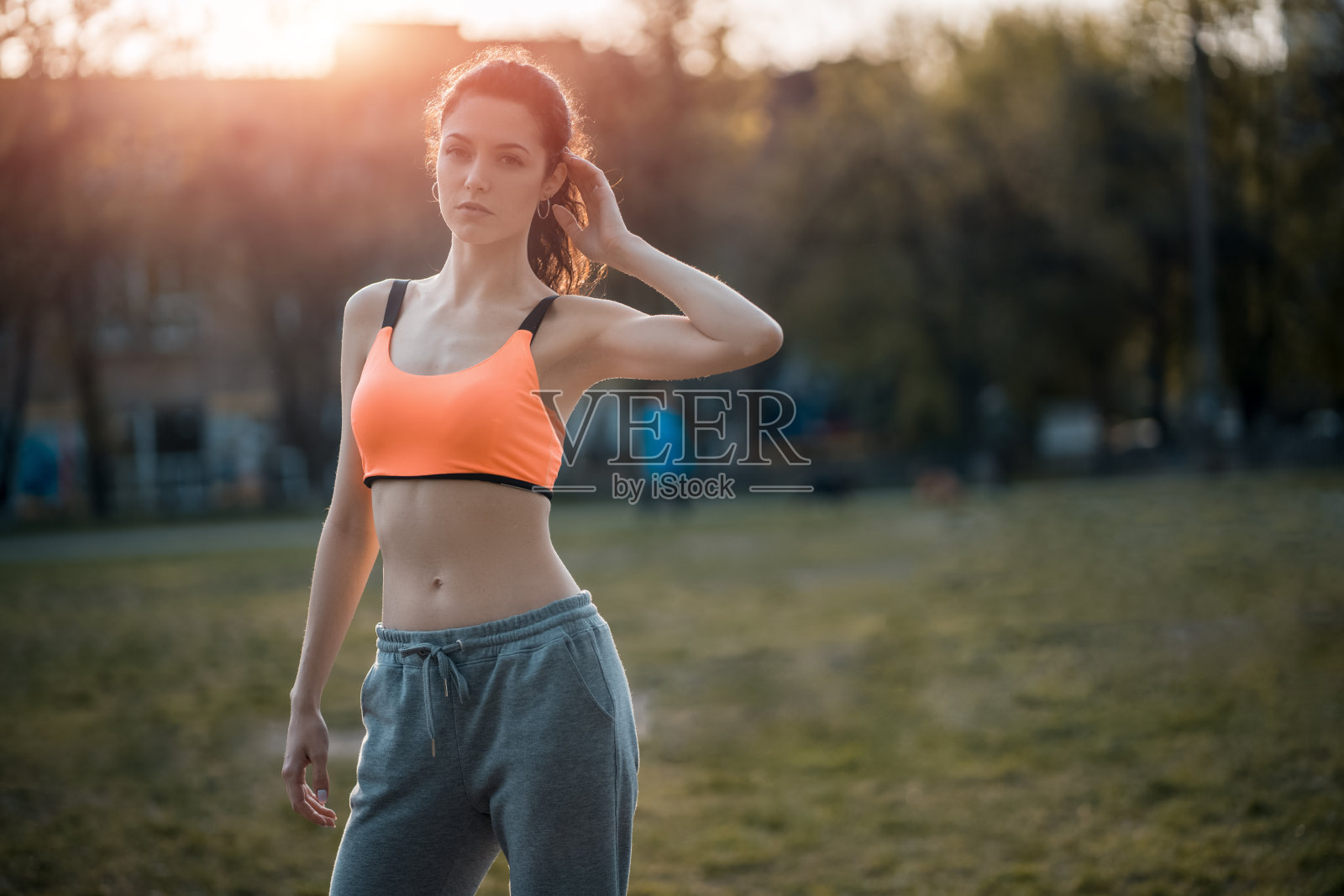 迷人的黑发女子在阳光下热身和伸展公园照片摄影图片