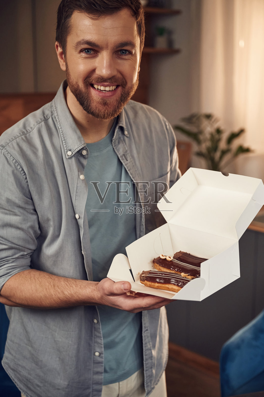 微笑着，露出糖果。人类与美味的甜点在生态盒子里。站在室内照片摄影图片