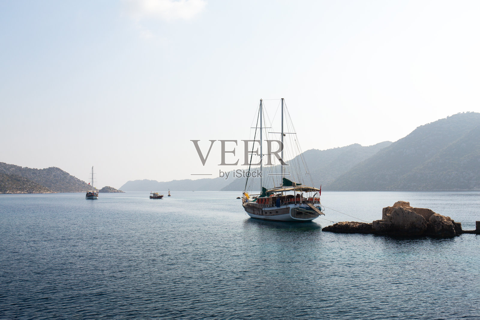 机动船。从船上看。地中海俯瞰群山。海波击中岩石的鸟瞰图与蓝绿色海水海滩。照片摄影图片