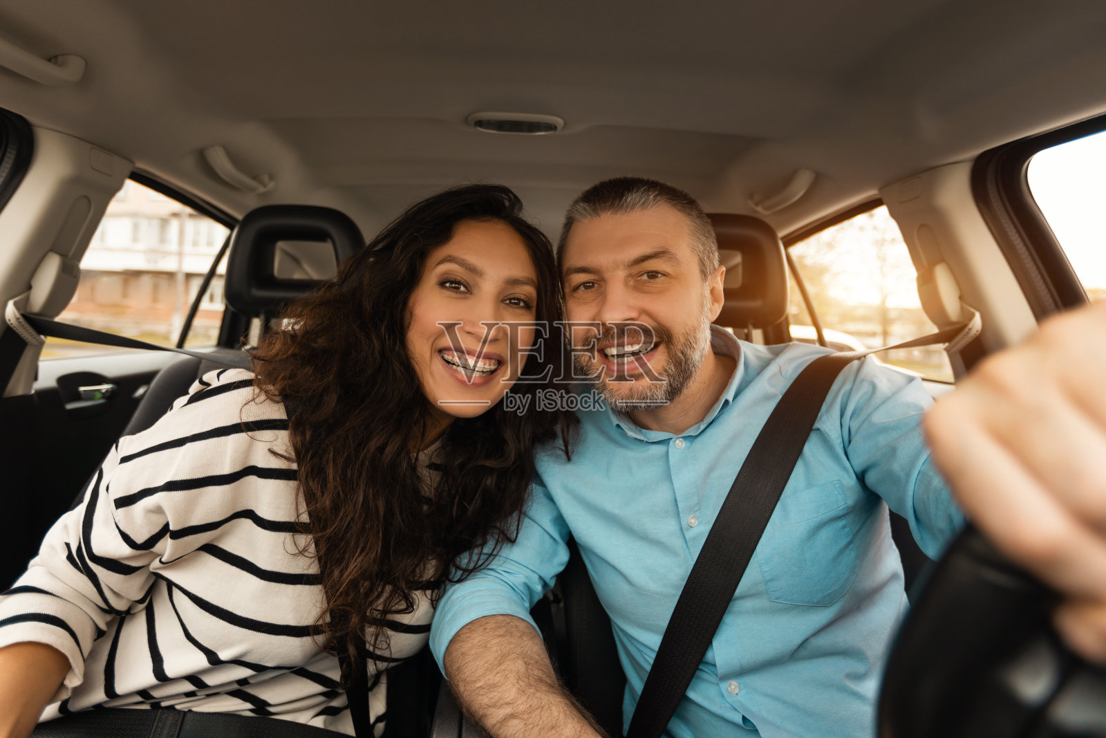 幸福的情侣坐在车里对着镜头摆姿势照片摄影图片