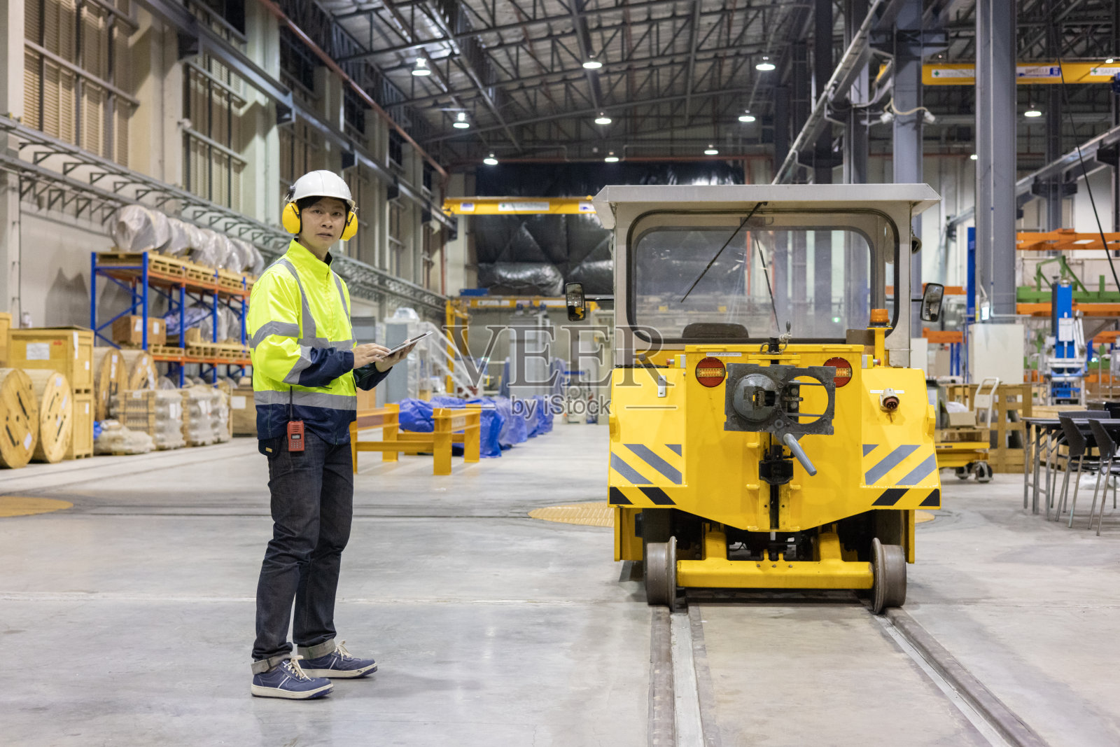 项目工程师在车辆段对列车柴油机、轨道进行检查照片摄影图片