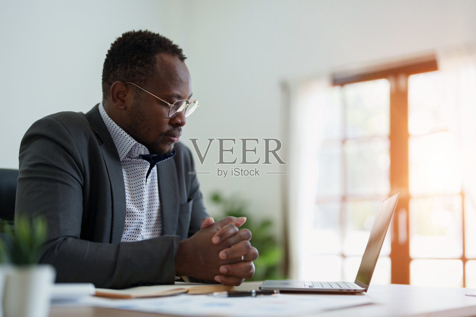 中年男子美国非洲人使用笔记本电脑与计划工作的财务文件，税务，外汇，会计和财务顾问照片摄影图片