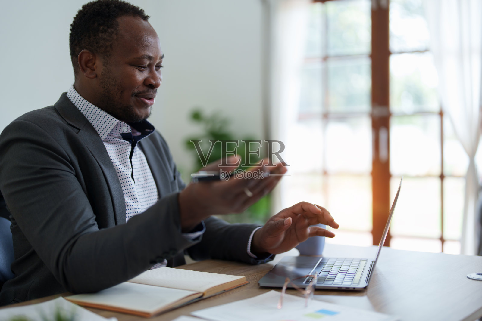 非裔美国人，视频电话和笔记本电脑，打招呼和会议，咨询或互联网策划在创业公司。在线会议，电脑网络研讨会，员工快乐问候照片摄影图片