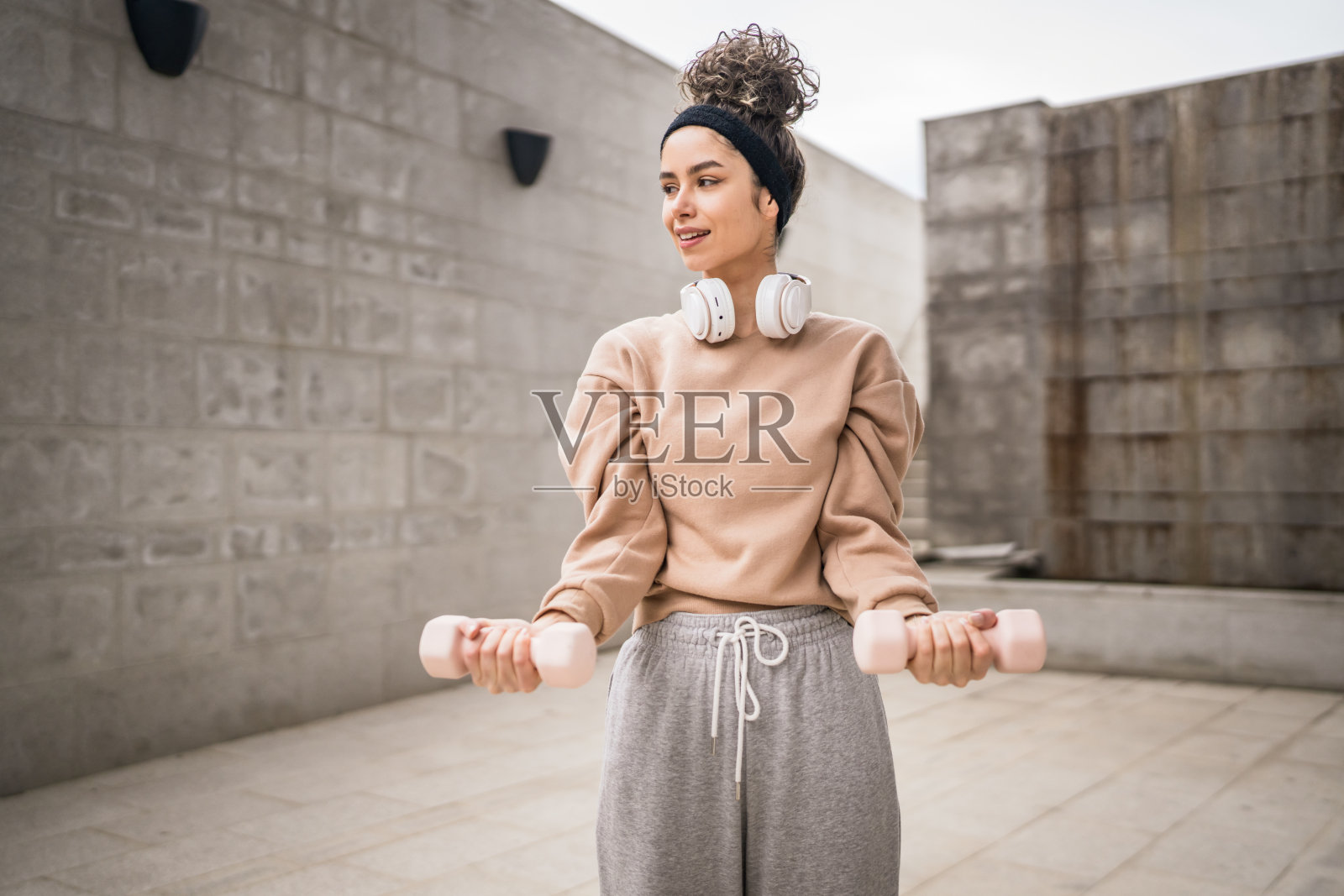 一位女士白天在户外练习哑铃重量照片摄影图片