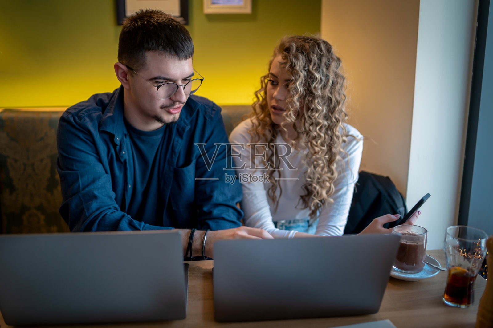 Business people working together at a café using their laptops照片摄影图片