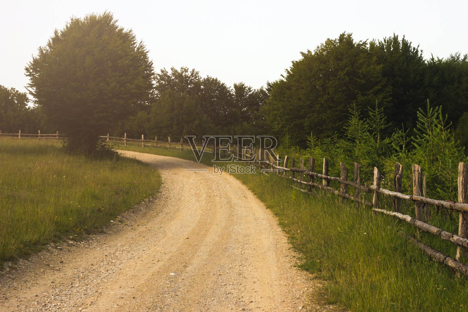 乡村道路和木制的旧栅栏。美丽的夏日景观，质朴的生活理念照片摄影图片