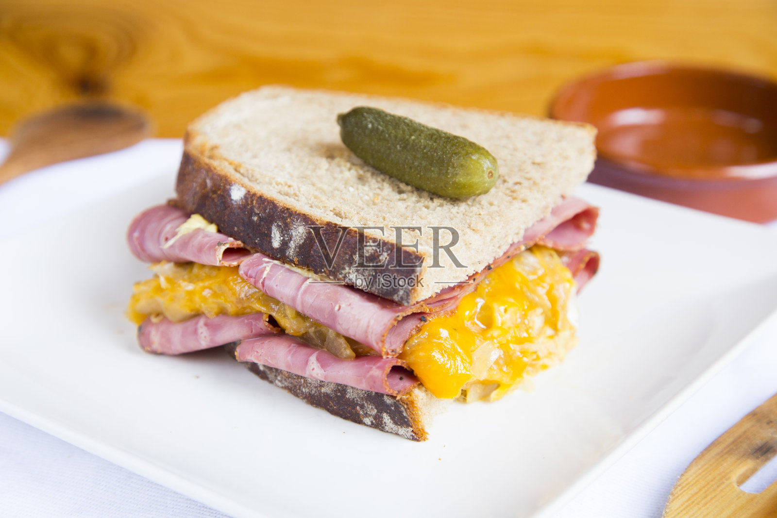 美味的美国熏牛肉和奶酪三明治配上腌黄瓜。照片摄影图片