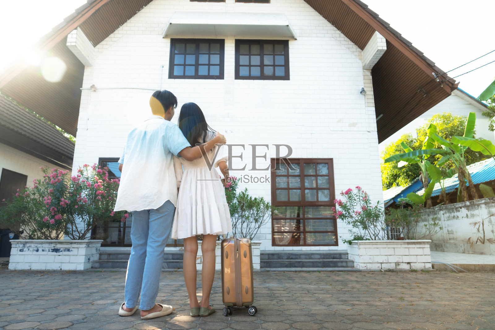 一对夫妇看着他们的新家的背影。照片摄影图片