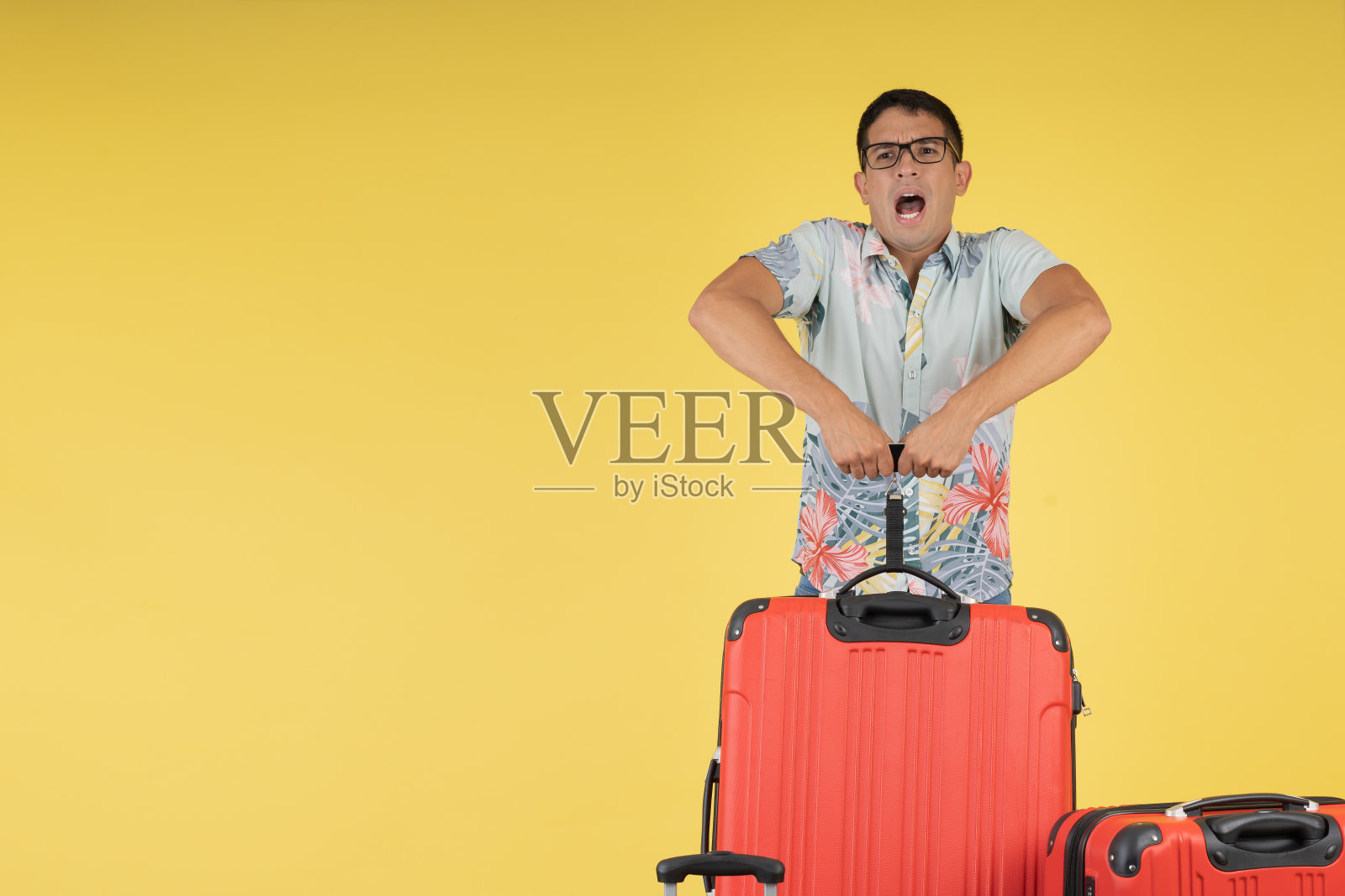 一个旅行者，当他举起行李箱时，惊讶于它的重量。照片摄影图片