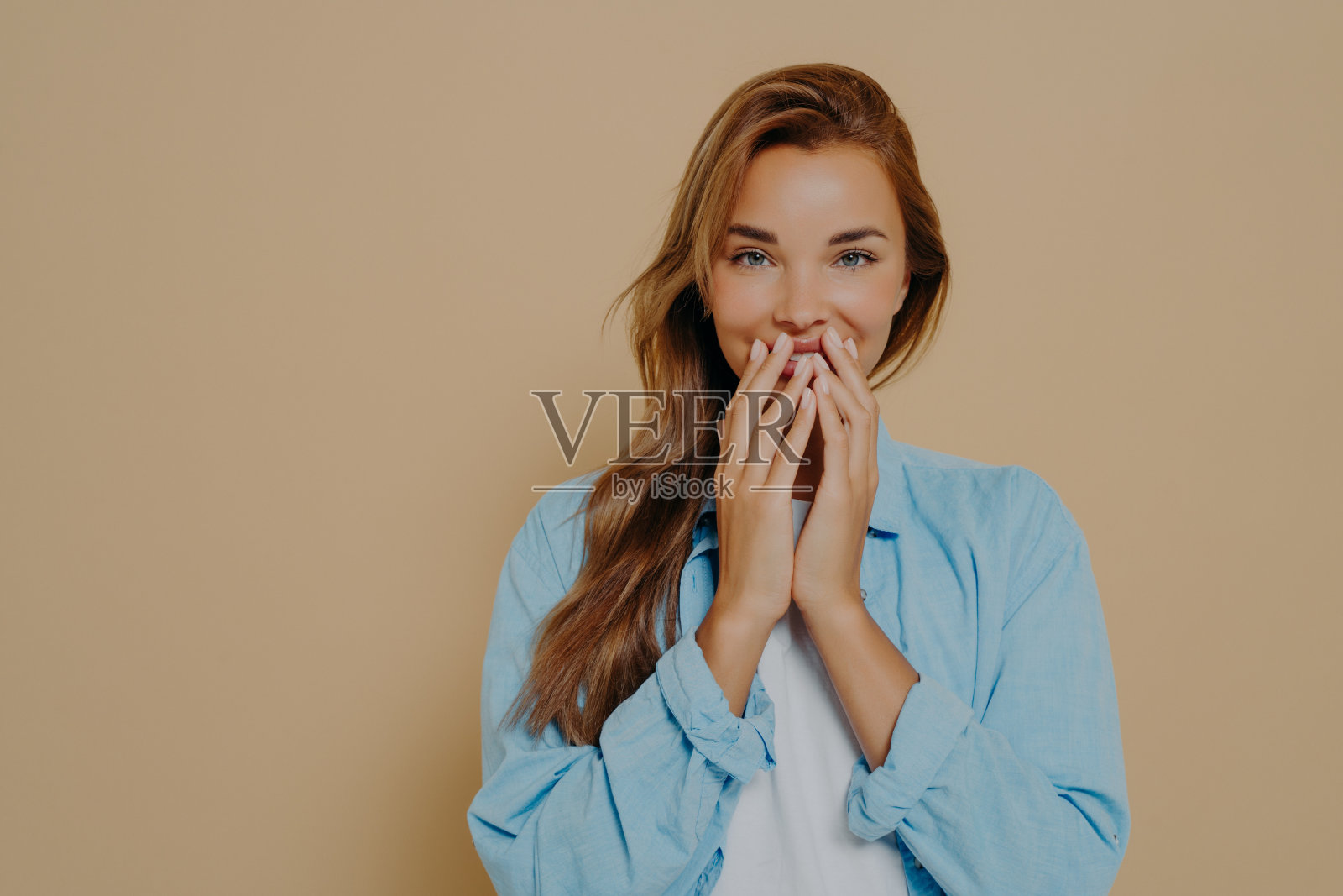 表情欢快的快乐女模特用手捂住嘴唇照片摄影图片