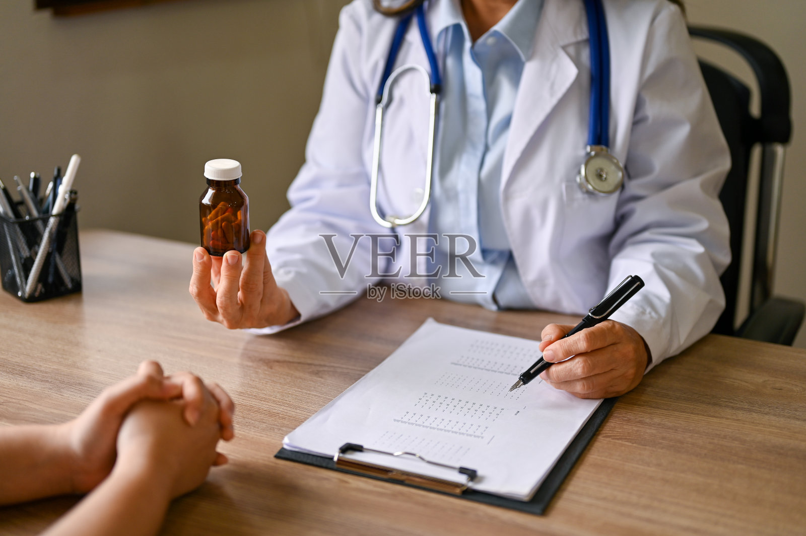 女医生:在诊所里给病人讲解并给予药物指导的女医生照片摄影图片