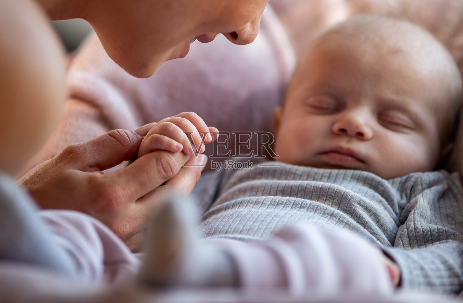 可爱的新生儿握着妈妈的手睡觉照片摄影图片