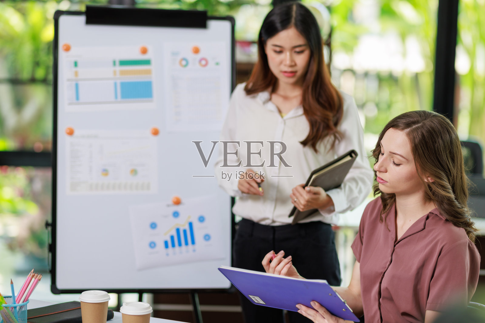 商业办公室女性工作的概念，女商人与她的合作伙伴一起制定投资计划，并通过使用计算器和笔记本电脑分析文件商业投资图表数据照片摄影图片