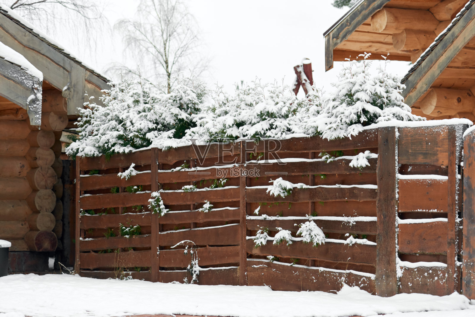 Snow-coveredÂ wooden fence in the countryside. Winter background照片摄影图片