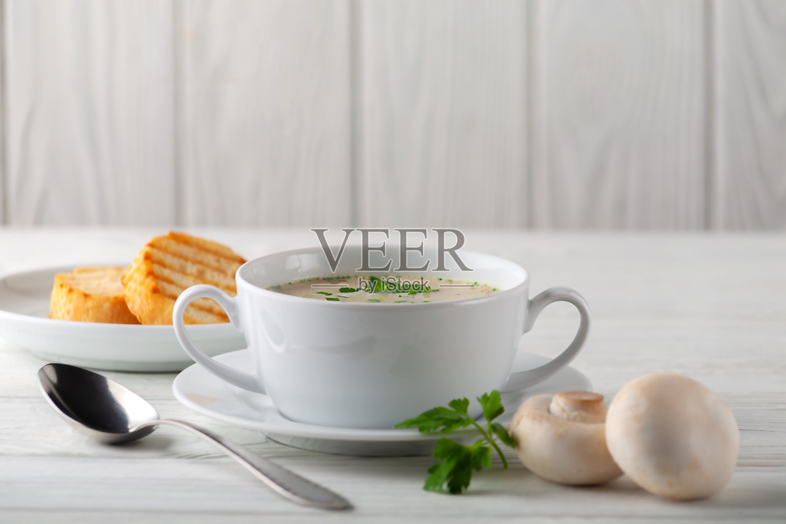 蘑菇奶油汤放在白色木板上。侧视图照片摄影图片