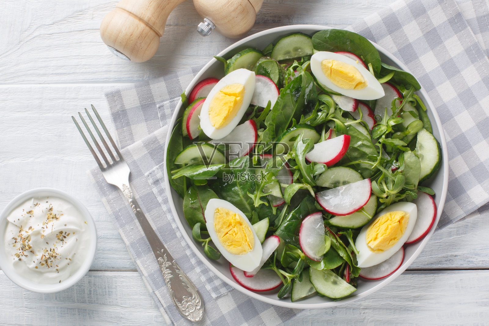 新鲜的波兰春季沙拉由萝卜，黄瓜，生菜混合，菠菜和鸡蛋特写在一个盘子上的木桌特写在盘子上。水平俯视图照片摄影图片