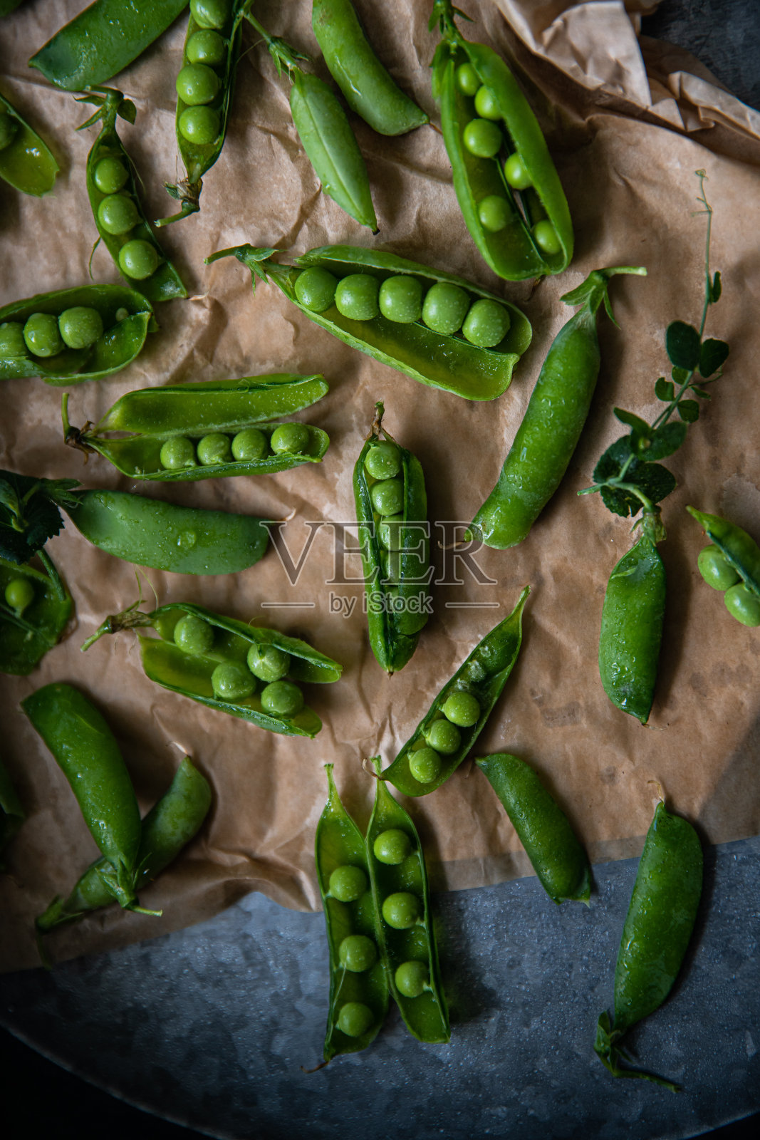 新鲜的绿色豌豆荚在托盘上。照片摄影图片
