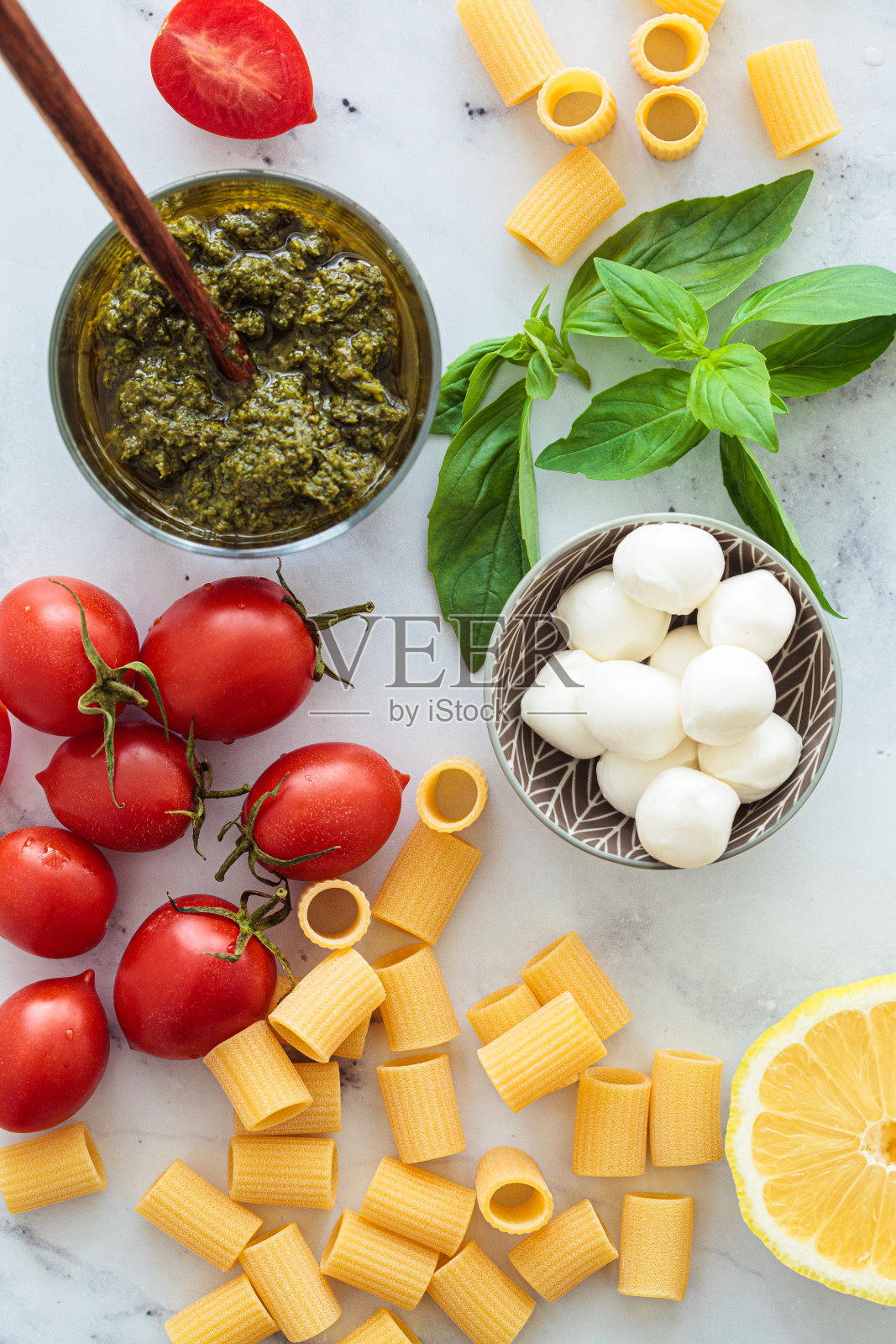 用西红柿、香蒜沙司和马苏里拉奶酪制作素食意面的原料。意大利料理概念。照片摄影图片